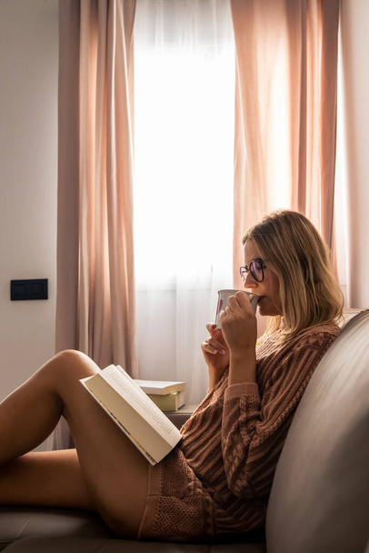 Fiatal nő olvasó által az ablak - Fotó, kép