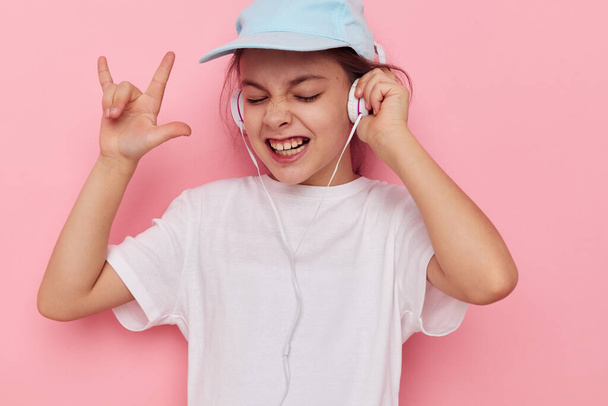Portrait of happy smiling child girl listening to music on headphones isolated background - Fotografie, Obrázek