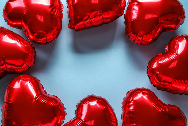 Frame gemaakt van hartvormige luchtballonnen voor Valentijnsdag op blauwe achtergrond - Foto, afbeelding