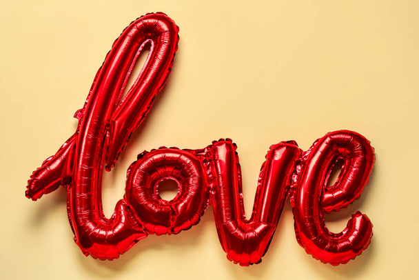 Balloon in shape of word LOVE on beige background. Valentine's Day celebration - Photo, image