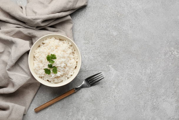Bowl with tasty boiled rice on grey background - Fotografie, Obrázek