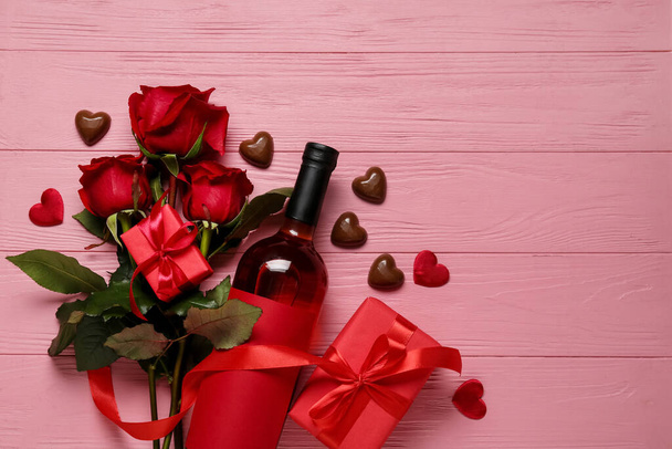Koostumus pullon viiniä, lahjoja ja ruusuja Ystävänpäivä väri puinen tausta - Valokuva, kuva