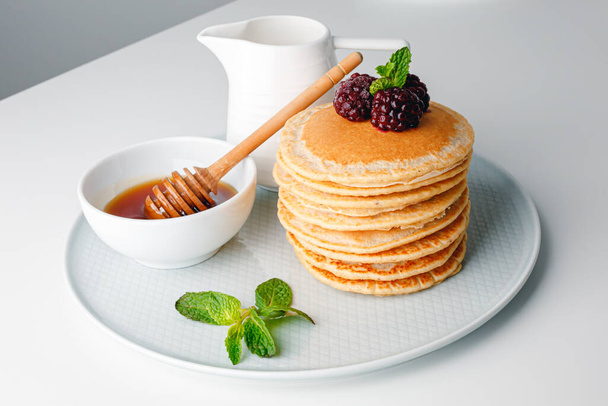 American pancakes with fresh blueberry, raspberry and honey. Healthy morning breakfast. Homemade American pancakes with Blackberries and golden honey. Healthy morning breakfast. - Фото, зображення