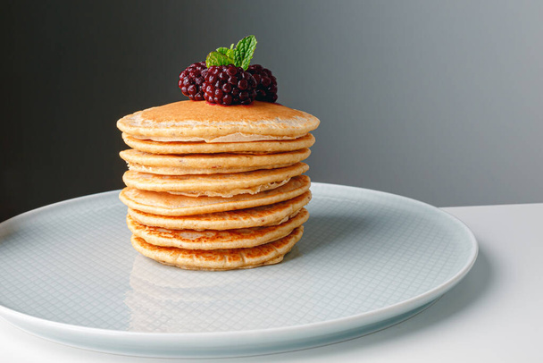 American pancakes with fresh blueberry, raspberry and honey. Healthy morning breakfast. Homemade American pancakes with Blackberries and golden honey. Healthy morning breakfast. - Photo, image