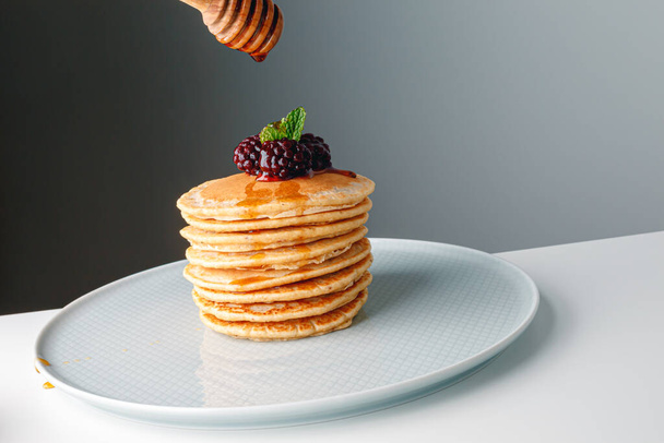 American pancakes with fresh blueberry, raspberry and honey. Healthy morning breakfast. Homemade American pancakes with Blackberries and golden honey. Healthy morning breakfast. - Foto, Imagen
