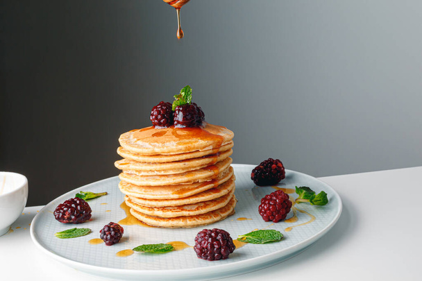 American pancakes with fresh blueberry, raspberry and honey. Healthy morning breakfast. Homemade American pancakes with Blackberries and golden honey. Healthy morning breakfast. - Foto, Imagem