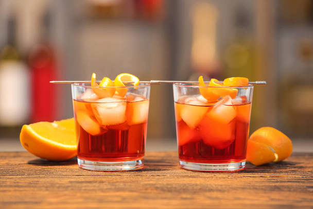 Glasses of tasty Negroni cocktail on table against blurred background - Foto, imagen