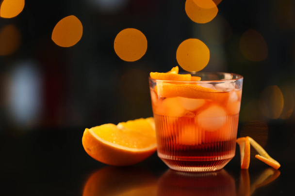 Glass of tasty Negroni cocktail on table against blurred background - Foto, imagen