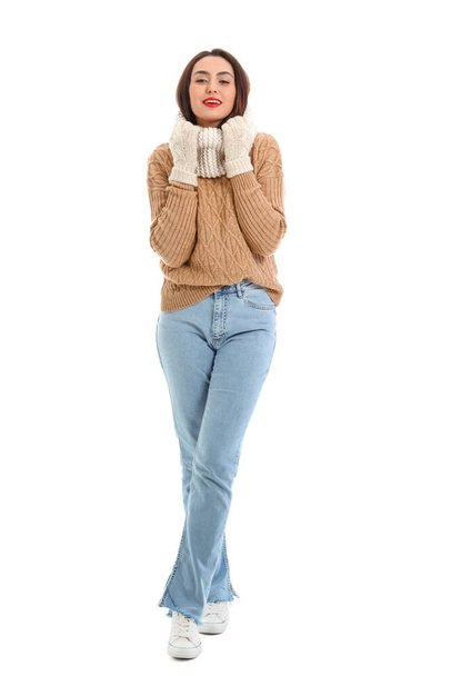Pretty young woman in warm sweater on white background - 写真・画像