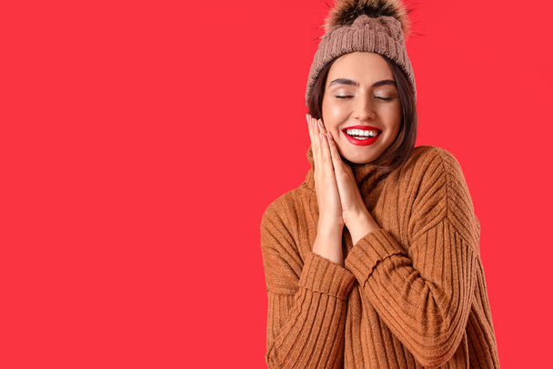 Pretty young woman in warm sweater on color background - Photo, Image