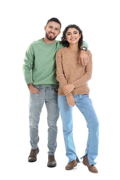 Happy young couple in warm sweaters on white background - Zdjęcie, obraz