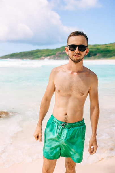 熱帯の島で休暇中の若い男ラ・ディジェ,熱帯のビーチで休暇中にビーチを歩く中年の男セイシェル - 写真・画像