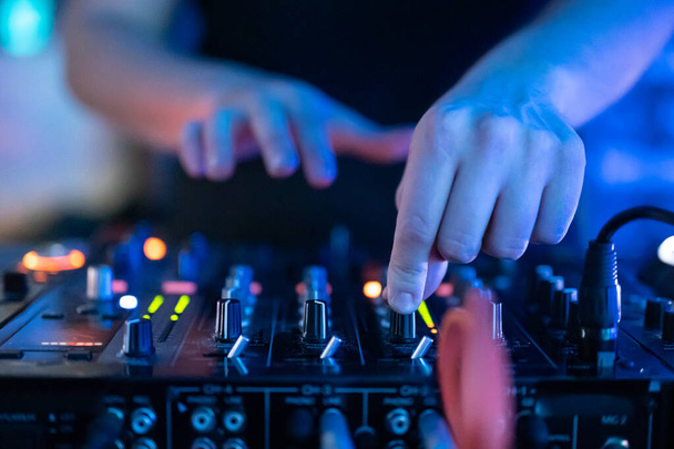 Крупним планом Вид спереду рук DJ, що контролюють музичний стіл в нічному клубі
. - Фото, зображення