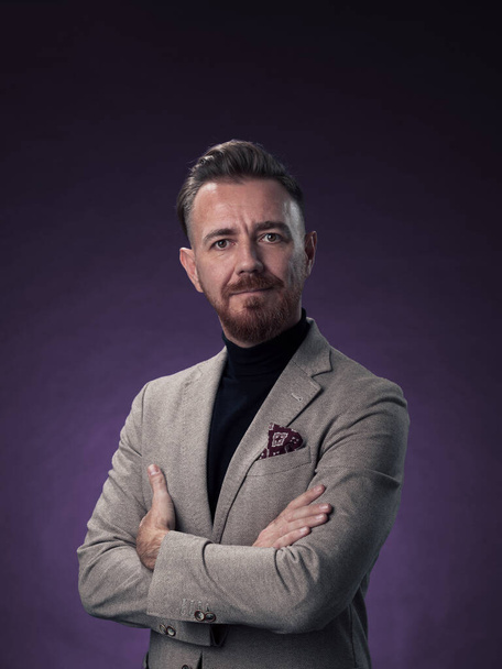 Portrait of a stylish elegant senior businessman with a beard and casual business clothes in photo studio isolated on dark background gesturing with hands. High quality photo - Fotó, kép