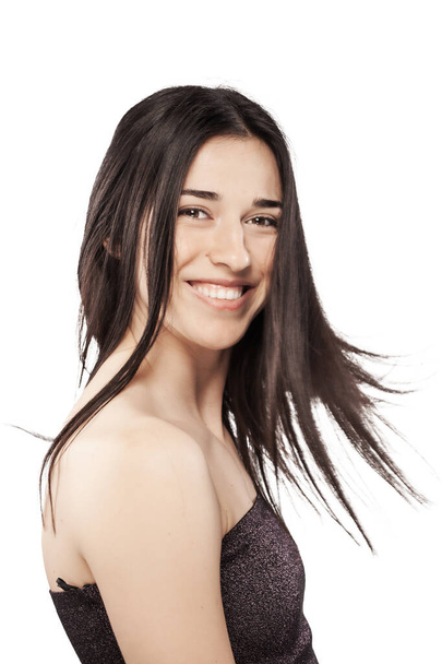 studio portrait of a beautiful brunette girl smiling against white backgroung. - Fotó, kép