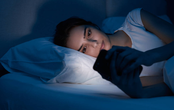 Young woman using cellphone at night - Valokuva, kuva