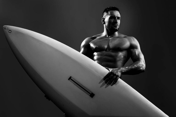 Sexy surfer with a surfboard. Portrait of handsome athlete with serf board. Male beach leisure, summer vacation. - Foto, Imagem