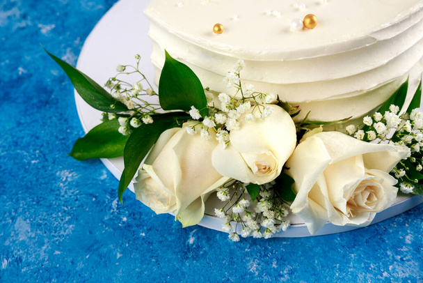 Anniversary cake with white roses on blue background. Close up. - Foto, Imagen