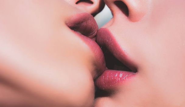 Two women kissing. Lesbian couple kiss lips. Sexy lesbian lovers foreplay. Closeup of women mouths kissing. - 写真・画像