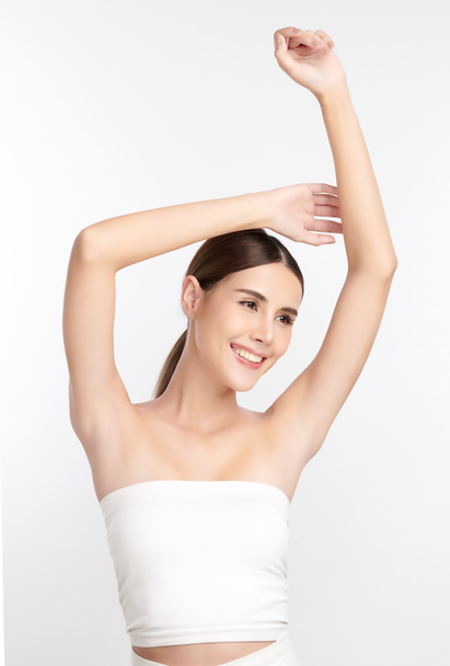 Beautiful Young Asian woman lifting hands up to show off clean and hygienic armpits or underarms on white background, Smooth armpit cleanliness and protection concept. - Photo, Image