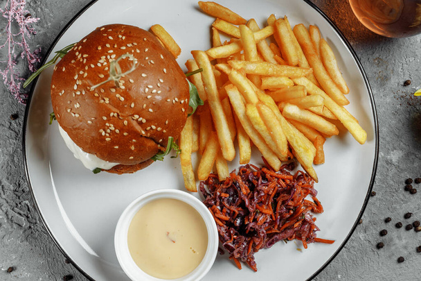 burger s hranolkama a omáčkou na bílém talíři - Fotografie, Obrázek
