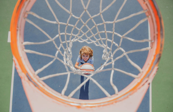 Kid playing basketball. Full length, top view of a kid playing with a basketball. - Φωτογραφία, εικόνα