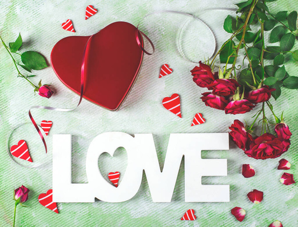 Festive composition of love for Valentines day made with red gift box and roses, hearts and word Love. Flat lay. - Foto, Imagen