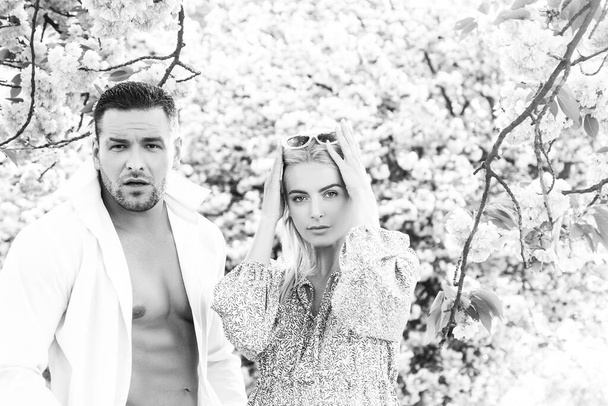 Spring fashion. Outdoor portrait of fashionable couple posing near flowering sakura. Model wearing stylish accessories clothes. Beauty and fashion. City lifestyle. - Fotografie, Obrázek