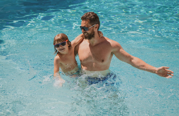Father and son swimming in pool, summer family. Child with dad playing in swimming pool. Summer vacation. Aquapark. Father and son leisure. - Φωτογραφία, εικόνα
