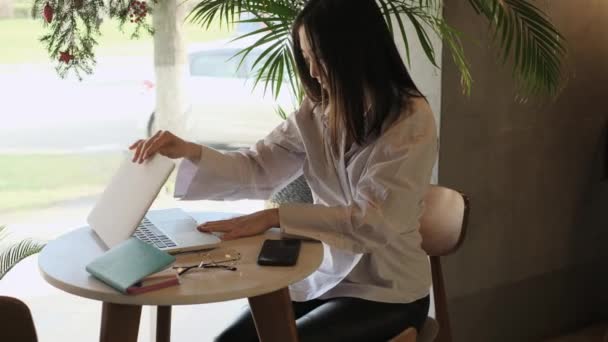 Asijská žena na volné noze pracující v kavárně - Záběry, video