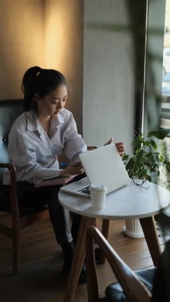 Asiática freelancer femenina trabajando en un café - Metraje, vídeo