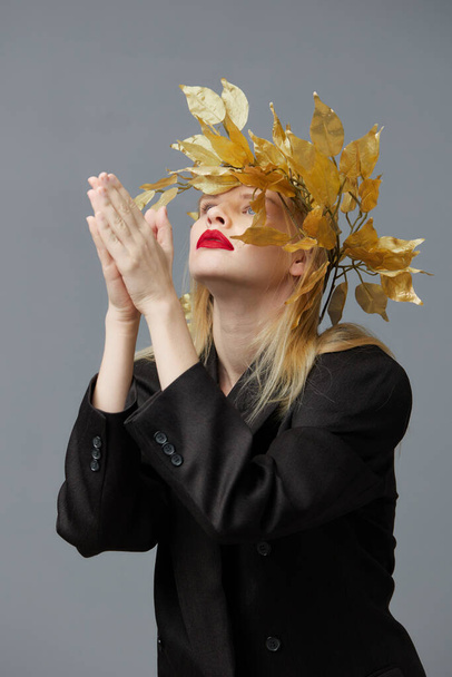 mujer de moda hojas de oro corona negro chaqueta labios rojos modelo de estudio inalterado - Foto, imagen