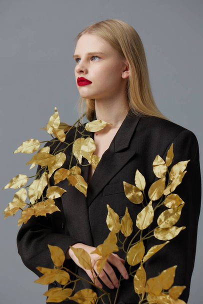 portrait of a woman fashion golden leaves in black jacket studio model unaltered - Foto, afbeelding