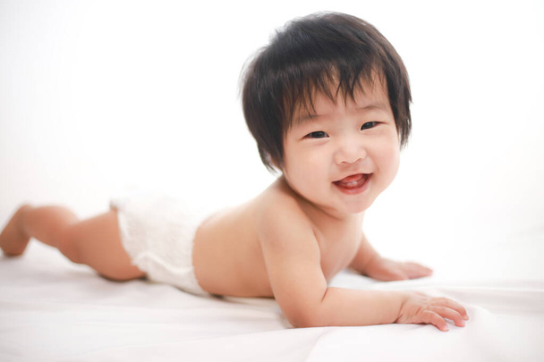 lindo asiático bebé chico acostado en la cama - Foto, Imagen