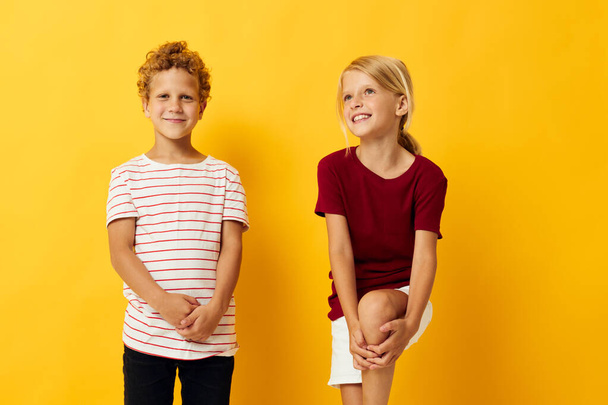 Boy and girl casual wear games fun together yellow background - Foto, afbeelding