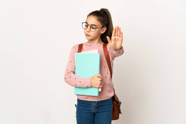 Little student girl over isolated background making stop gesture and disappointed - Photo, Image
