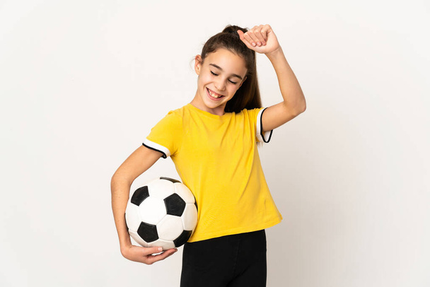 Маленькая девочка футболистка на белом фоне празднует победу - Фото, изображение