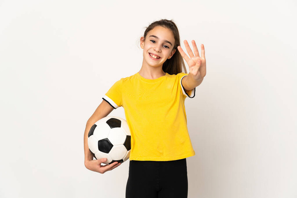 Piccola ragazza giocatore di calcio isolato su sfondo bianco felice e contando quattro con le dita - Foto, immagini