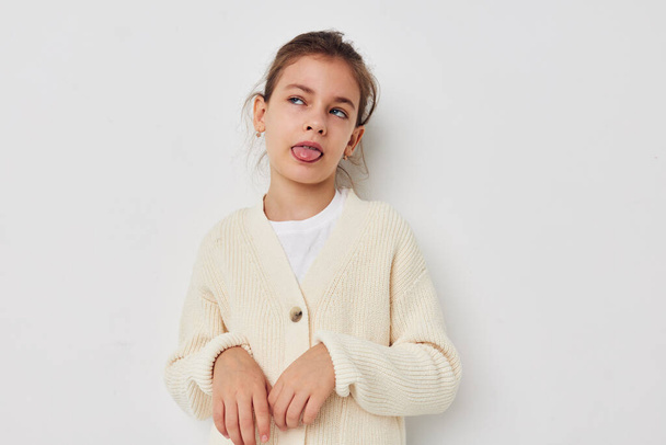 Portrait of happy smiling child girl posing in a white sweater childhood unaltered - Foto, imagen