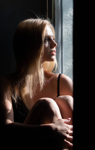Sensual girl near window. Romantic portrait of beautiful female model. Charming elegance model with sensual seductive look. Beauty sexy female face with dramatic studio light. - Fotoğraf, Görsel