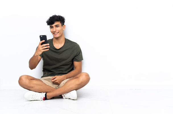 Young Argentinian man sitting on the floor making a selfie - Foto, Imagen