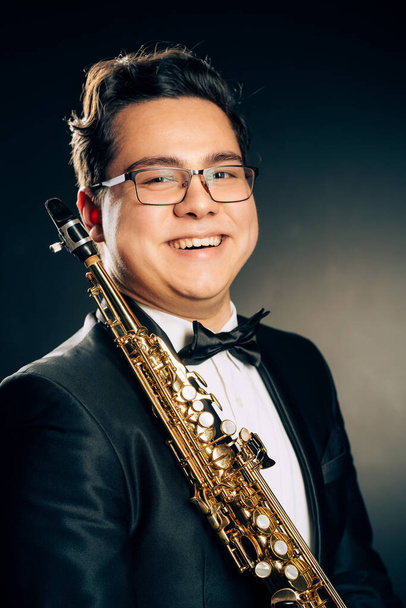 Young Japanese Saxophone Player Posing With Soprano Straight Saxophone.Musician with Brass Musical Instrument. Close-up Portrait. Black Background - Φωτογραφία, εικόνα