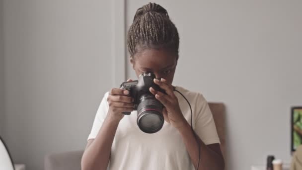 Waist up slowmo shot of African-American female food photographer taking pictures on professional camera in photo studio - Video