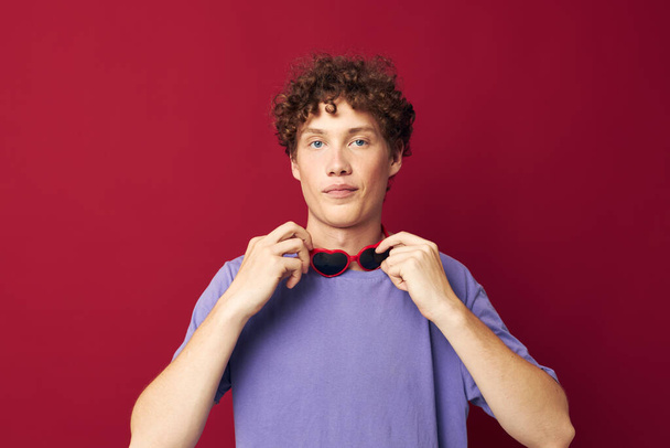 portrait of a young curly man hand gestures heart shaped glasses posing isolated background - 写真・画像