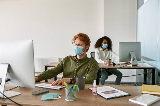 Employees work in office during Covid-19 pandemic - Foto, imagen
