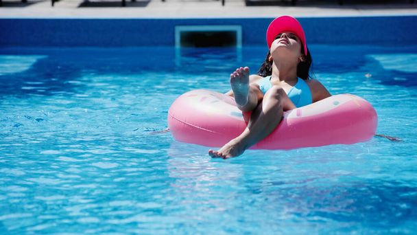 jovem mulher no anel de natação na piscina com água azul - Foto, Imagem