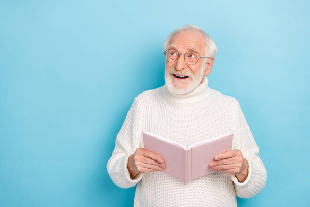 Photo of impressed aged beard man read book look promo wear spectacles pullover isolated on blue color background - Foto, afbeelding