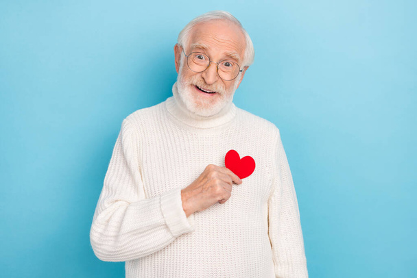 Photo of flirty old beard man hold heart wear spectacles sweater isolated on blue color background - Foto, Imagem