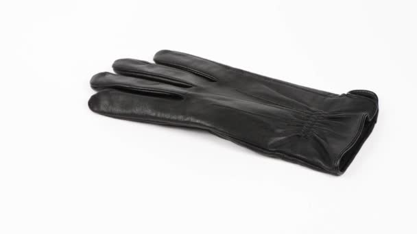 Zwarte leren handschoenen vallen van boven op een witte achtergrond. Zijaanzicht. 4K UHD-videobeelden 3840X2160. - Video