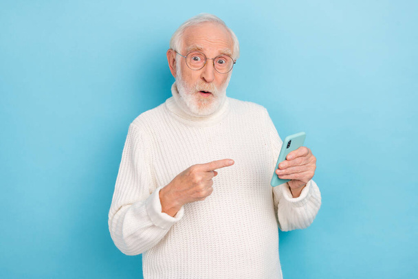 Photo of impressed aged beard man index telephone wear eyewear white turtleneck isolated on blue color background - Foto, Imagen